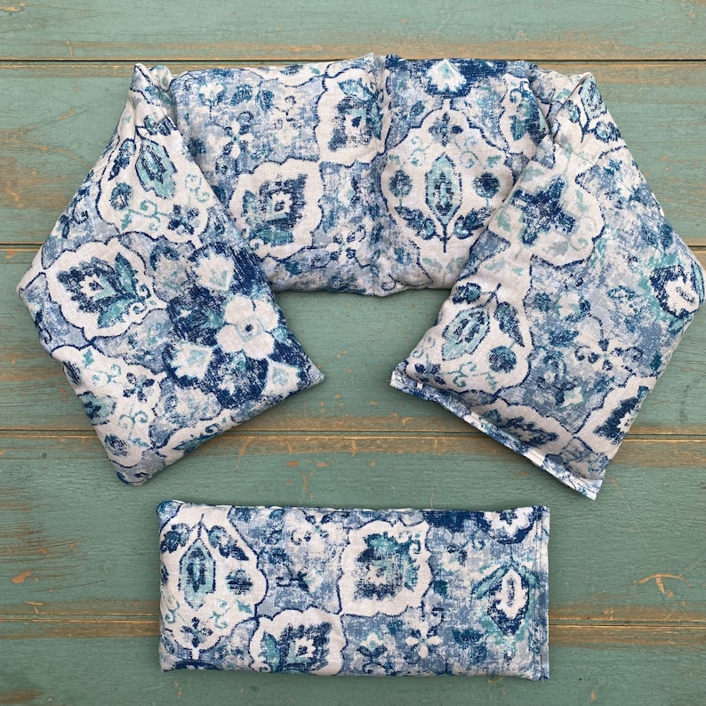 May include: Three blue and white patterned fabric neck wraps for hot or cold therapy. The wraps are rectangular and have a floral design.