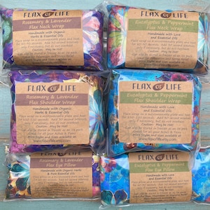 May include: Six colorful flax heat packs with labels that read "Flax of Life" and include the scents and types of packs: Rosemary & Lavender Flax Neck Wrap, Eucalyptus & Peppermint Flax Neck Wrap, Rosemary & Lavender Flax Shoulder Wrap, Eucalyptus & Peppermint Flax Shoulder Wrap, Rosemary & Lavender Flax Eye Pillow, Eucalyptus & Peppermint Flax Eye Pillow.  The packs are made with organic herbs and essential oils.