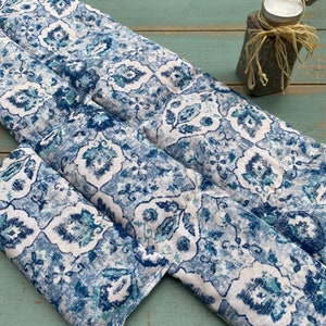 May include: Three blue and white patterned fabric heat packs. The fabric has a paisley design with a white background and blue and green accents.