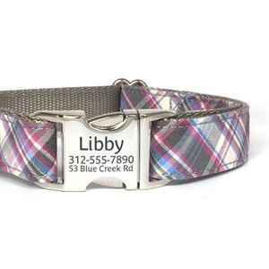 May include: A gray and white plaid dog collar with a silver buckle. The buckle has the name "Libby" and the phone number 312-555-7890 and address 53 Blue Creek Rd engraved on it.