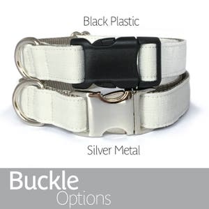 May include: Two dog collars with white canvas fabric and different buckle options. The top collar has a black plastic buckle, and the bottom collar has a silver metal buckle. Buckle Options.