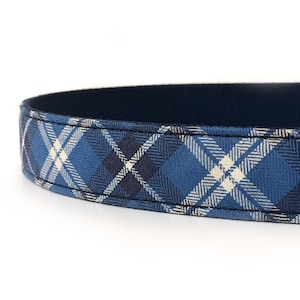 May include: A blue and white plaid dog collar with a navy blue backing.