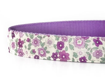 May include: A purple and white floral dog collar with a purple underside.