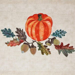 Könnte beinhalten: Ein Stoff-Applikation mit einem großen orangefarbenen Kürbis mit grünem Stiel, umgeben von bunten Herbstblättern und Eicheln. Das Design ist vor einem neutralen Hintergrund gehalten und erinnert an das Thema der Herbsternte.