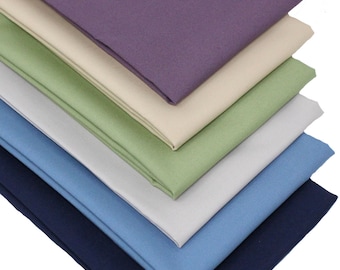 May include: A stack of six fabric swatches in various colors, including purple, beige, green, light gray, blue, and navy blue.