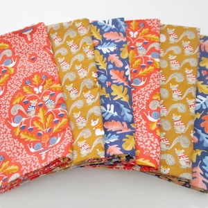 May include: A stack of folded fabric with colorful patterns. The fabrics feature repeating designs of squirrels, acorns, and leaves in shades of red, yellow, and blue. The fabrics are likely for sewing or crafting.