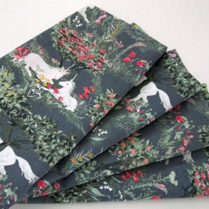 May include: Set of six grey cotton napkins with a white unicorn and floral pattern. The napkins feature a whimsical design with pink, green, and yellow flowers.