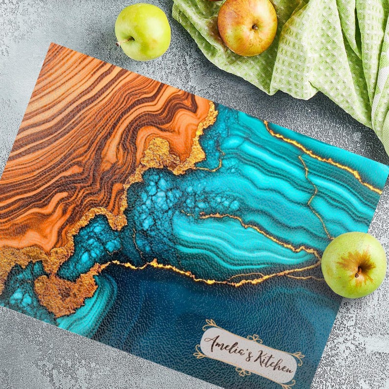 May include: A blue and orange marble-patterned cutting board with gold accents. The board has the text "Amelia's Kitchen" in a decorative font.