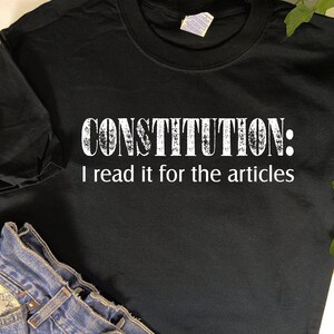 May include: Black t-shirt with white text that reads "CONSTITUTION: I read it for the articles".