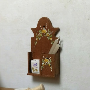 Kerzenhalter aus weißem, polychromem Holz mit Kerzen und Streichholzschachtel.