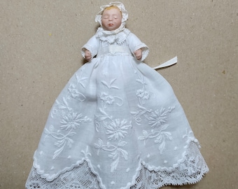 Bebé con faldón y gorro de encajes antiguos, porcelana, articulada escala 1:12 para casa de muñecas.