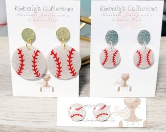 May include: Three pairs of baseball-themed earrings. The earrings are white with red stitching and glitter. The earrings are on cards with the text "Kimberly's Collections Handmade Jewelry with a Southern Flair".