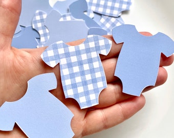 May include: A pile of light blue baby onesie shaped paper cutouts. Some of the onesies have a white and light blue gingham pattern.
