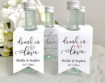 May include: Set of four mini liquor bottles with white labels that say "drunk in love" with a red heart design. The labels also include the names Maddie & Stephen and the date 10.7.20xx.