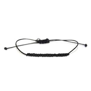 May include: Black beaded bracelet with adjustable sliding knot closure. The bracelet features small, round black beads strung on a black cord. The design is simple and minimalist, suitable for everyday wear.