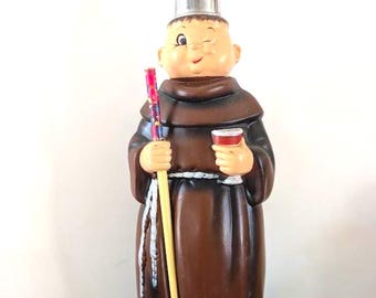Estatua de cerámica de un monje guiñando un ojo