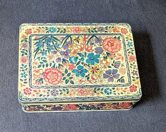 Lata colorida estilo Daher con relieve de flores multicolores y textura