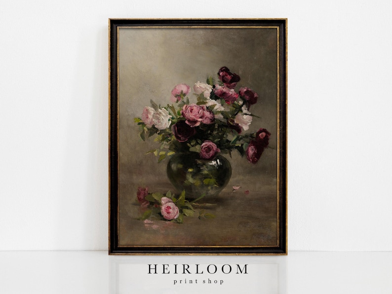 May include: A framed vintage still life painting depicting a bouquet of pink and burgundy roses in a green glass vase. The artwork has a dark frame and a neutral background. The text "HEIRLOOM print shop" is at the bottom.