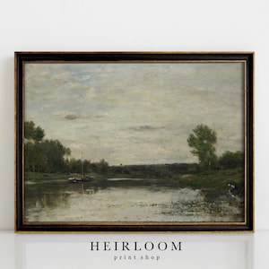 May include: A framed landscape painting depicts a tranquil river scene. The artwork features a cloudy sky, lush green trees, and a dark brown frame. The painting has a vintage aesthetic, with a focus on natural elements.