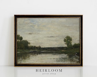 May include: A framed landscape painting depicts a tranquil river scene. The artwork features a cloudy sky, lush green trees, and a dark brown frame. The painting has a vintage aesthetic, with a focus on natural elements.