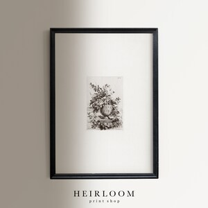 K&ouml;nnte beinhalten: Ein Schwarzwei&szlig;-Vintage-Botanischer Druck einer Vase voller Blumen. Der Druck ist in einem schwarzen Rahmen gerahmt und h&auml;ngt an einer wei&szlig;en Wand. Der Druck ist mit "HEIRLOOM print shop" betitelt.