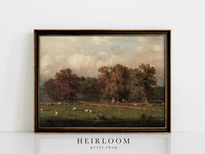 May include: A framed vintage landscape painting featuring a pastoral scene with trees, sheep, and a dirt path. The artwork has a dark wooden frame with gold trim. The painting's color palette includes greens, browns, and blues.