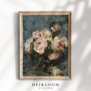 Op de afbeelding: Een ingelijst bloemenschilderij met een boeket witte en roze rozen tegen een blauwe achtergrond. Het kunstwerk heeft een vintage uitstraling met zichtbare penseelstreken en is geplaatst in een lichtgekleurde houten lijst. De tekst "HEIRLOOM print shop" staat onderaan.