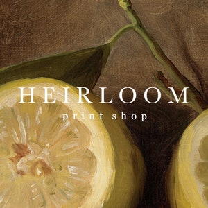 May include: A still-life painting featuring a sliced lemon with a bright yellow interior and a green leaf. The text "HEIRLOOM print shop" is displayed in white letters.