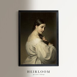 Op de afbeelding: Een vintage olieverfschilderij van een vrouw in een witte jurk, met haar haar naar achteren getrokken, die naar haar hand kijkt. Het schilderij is ingelijst in een zwart frame.