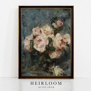 Op de afbeelding: Een ingelijste vintage bloemenprint met een boeket lichtroze en witte rozen. De rozen staan tegen een donkerblauwe achtergrond met zichtbare penseelstreken. De lijst is zwart met gouden accenten. De tekst "HEIRLOOM print shop" staat onderaan.