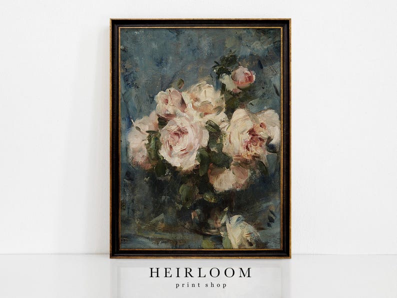 Op de afbeelding: Een ingelijste vintage bloemenprint met een boeket lichtroze en witte rozen. De rozen staan tegen een donkerblauwe achtergrond met zichtbare penseelstreken. De lijst is zwart met gouden accenten. De tekst "HEIRLOOM print shop" staat onderaan.