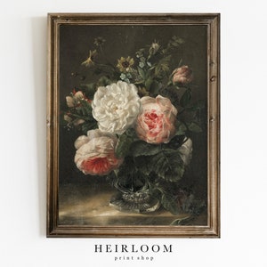 May include: A vintage framed painting of a still life featuring a bouquet of white and pink roses in a crystal vase. The roses are surrounded by green leaves and other flowers, including small yellow flowers. The painting has a dark brown background and a gold frame.