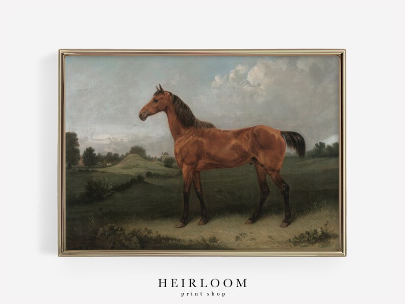 Puede incluir: Una impresi&oacute;n vintage enmarcada de un caballo marr&oacute;n de pie en un campo. El caballo tiene una melena y cola oscuras, con un cielo azul claro y un paisaje verde de fondo. La impresi&oacute;n est&aacute; en un marco dorado. El texto "HEIRLOOM print shop" est&aacute; en la parte inferior.