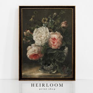 Könnte beinhalten: Gerahmtes Vintage-Stillleben mit Blumen. Das Kunstwerk zeigt einen Strauß weißer und rosa Rosen mit grünem Laub in einer Glasvase vor dunklem Hintergrund. Der Rahmen ist dunkel mit goldenen Akzenten. Der Text "HEIRLOOM print shop" befindet sich unten.