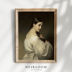 Op de afbeelding: Een vintage olieverfschilderij van een vrouw in een witte jurk, ingelijst in een licht houten lijst.