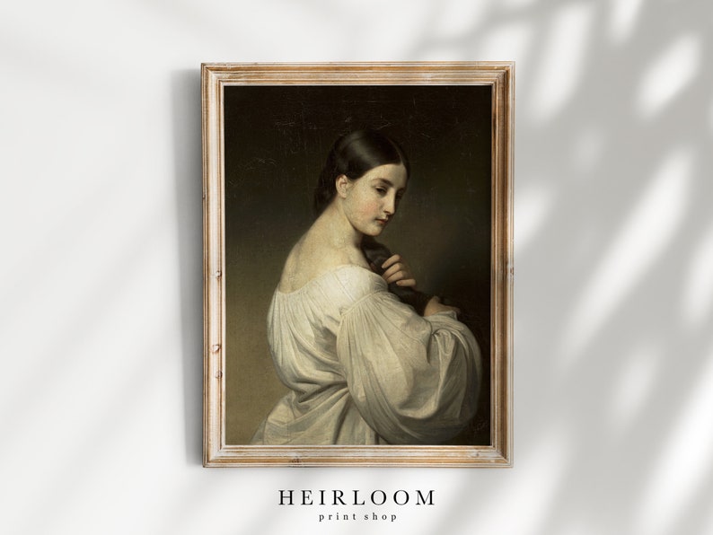 Op de afbeelding: Een vintage olieverfschilderij van een vrouw in een witte jurk, ingelijst in een licht houten lijst.