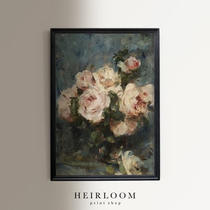 Op de afbeelding: Een ingelijst bloemstilleven schilderij. Het kunstwerk toont een boeket lichtroze en witte rozen in een donkere vaas tegen een blauwgroene achtergrond. De lijst is zwart. De tekst "HEIRLOOM print shop" staat onderaan.