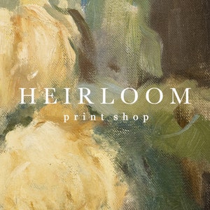 Op de afbeelding: Een olieverfschilderij met een close-up van cr&egrave;mewitte gele rozen en groen blad. Het kunstwerk heeft zichtbare penseelstreken en een getextureerd uiterlijk. De tekst "HEIRLOOM print shop" staat over de afbeelding.