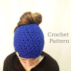 Può includere: Un cappello all'uncinetto blu reale con un dettaglio a bottone. Il cappello è indossato con i capelli raccolti in uno chignon. Il testo "Crochet Pattern" è visibile.