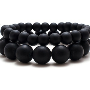 May include: Two black beaded bracelets, one with 8mm beads and one with 12mm beads.