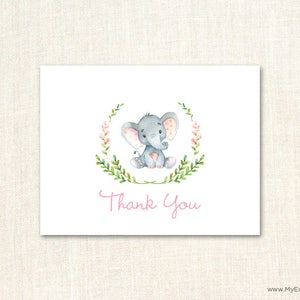 May include: A thank you card with a watercolor illustration of a gray elephant with pink accents sitting in a wreath of green leaves and pink flowers. The text "Thank You" is written in pink below the elephant.