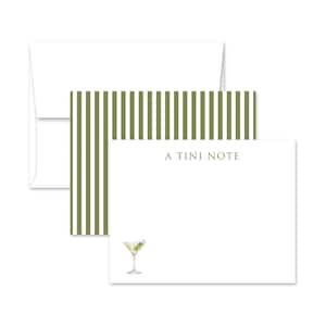 May include: Stationery set featuring a white envelope, a notepad with olive green striped accents, and a notepad with a martini illustration. The notepad reads "A TINI NOTE". The martini has an olive garnish.