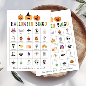 May include: Two white Halloween Bingo game cards featuring colorful illustrations of pumpkins, ghosts, bats, and skeletons. Each card has a five-by-five grid with various holiday icons and the text "HALLOWEEN BINGO" and "The first to get five in a row wins!"