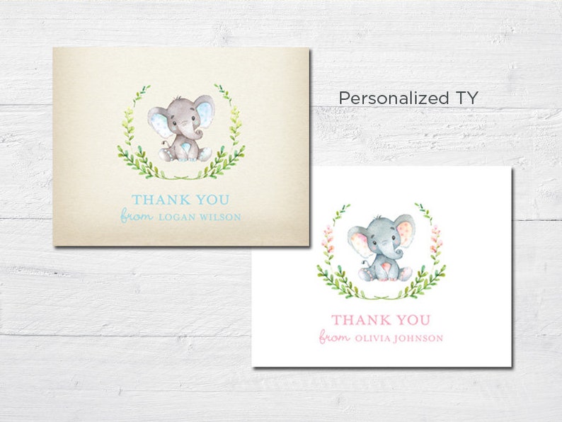 May include: Two thank you cards with a watercolor illustration of an elephant in a wreath of leaves. The card on the left has a blue wreath and the card on the right has a pink wreath. The text on the left card reads "Thank You from Logan Wilson". The text on the right card reads "Thank You from Olivia Johnson".