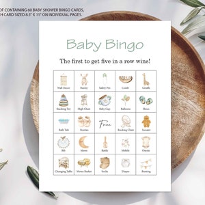 May include: A printable baby shower bingo card with a green title "Baby Bingo" and the text "The first to get five in a row wins!"  The card has a 5x5 grid with images of baby items such as a rattle, booties, a rocking chair, a diaper, and a high chair.