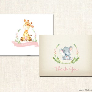 May include: Two thank you cards with a pink floral wreath design. One card features a giraffe with brown spots and the other card features a gray elephant with pink ears. Both cards have the text "Thank You" in pink.