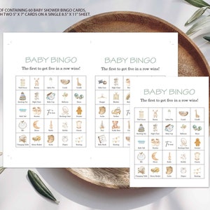 May include: A set of 60 printable baby shower bingo cards. Each card features a 5x5 grid with images of baby items like a high chair, rattle, and booties. The text "BABY BINGO" and "The first to get five in a row wins!" is at the top of each card.