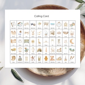 May include: A printable calling card with illustrations of baby items. The card features a grid of 36 squares, each containing a different baby item, such as a baby book, a baby bottle, a crib, a diaper, a giraffe, a rattle, a rocking horse, a teddy bear, and a teether. The card is designed in a neutral color palette of beige, brown, and white.