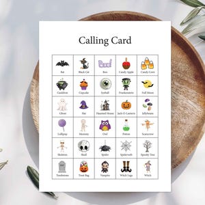 May include: A white rectangular calling card featuring a grid of twenty-five Halloween-themed illustrations. Each square contains a small icon such as a bat, black cat, ghost, pumpkin, or spider, with the corresponding label printed in black text below.