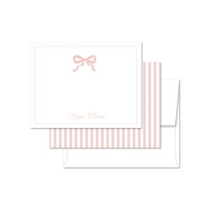 May include: Pink and white striped stationery set with a pink bow and the name "Megan Williams" printed on the card.